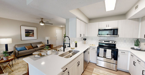 Modern kitchen in an apartment in Atlanta, GA, featuring sleek cabinetry, stainless steel appliances, and a spacious countertop with contemporary lighting.
